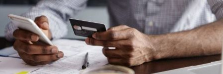 businessman using business credit card on phone to purchase