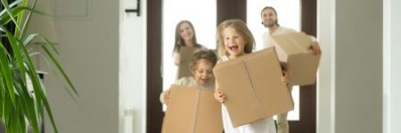 happy family carrying boxes into their new home