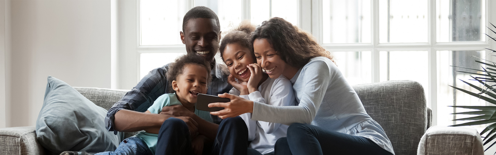 family laughing together on their mobile phone