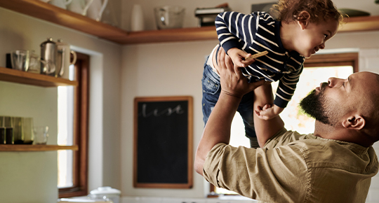 dad and son giggling in a kitchen