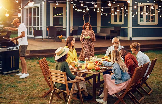 family playing frisbee with dog in yard