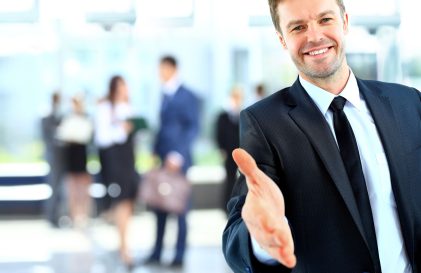 a man in a suit and tie giving a thumbs up.