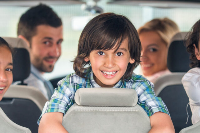 a group of children sitting in the back of a car.