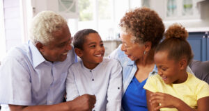 a family sitting on a couch smiling at each other.
