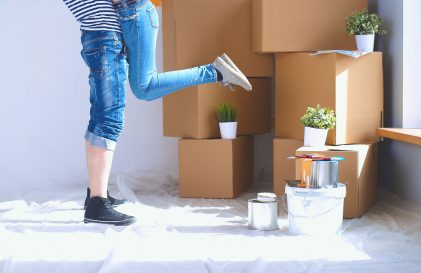 a woman standing in front of a pile of boxes.