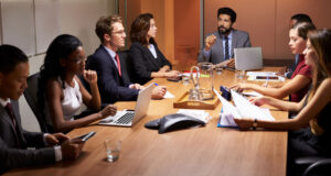 a group of people sitting around a conference table.