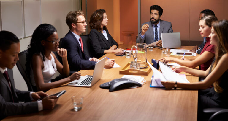 a group of people sitting around a conference table.