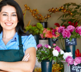 a woman standing in front of a flower shop.