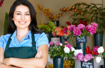 a woman standing in front of a flower shop.
