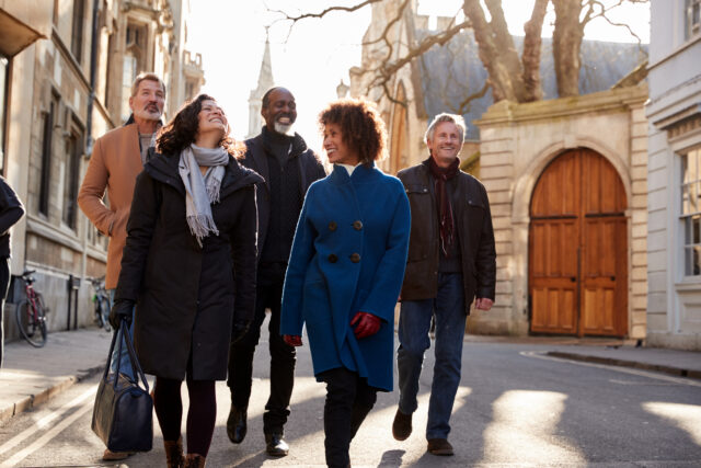 group of older people walking down the street laughing