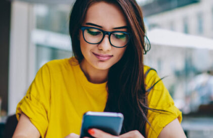 woman in yellow banking on her mobile device