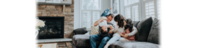 family playing on the couch in their home living room.