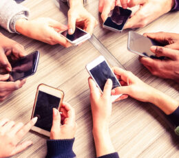 circle of hands with cell phones