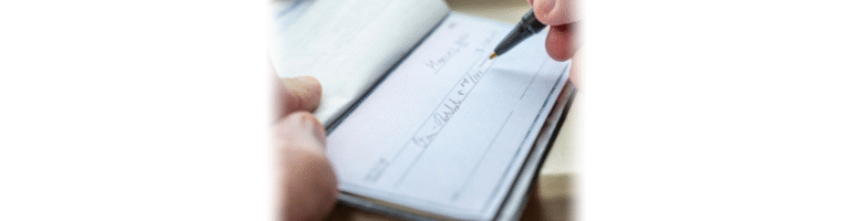 person writing a check in danger of check fraud
